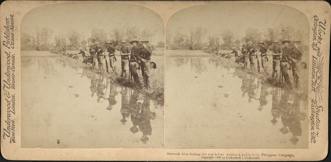 Skirmish Line halting for rest before wading a paddy-field, Philippine Campaign.